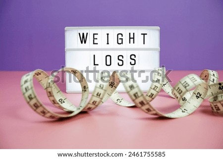 Weight Loss letterboard text on LED Lightbox and Measuring tape on pink and purple background, Healthcare concept