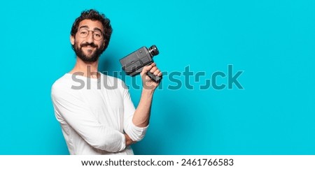young crazy bearded man with a super 8 camera