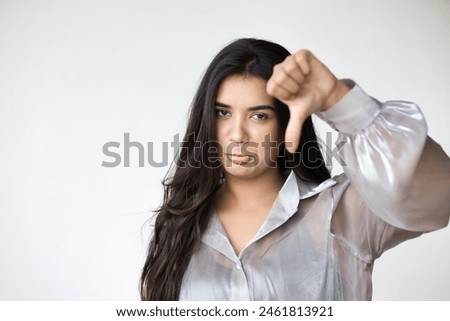Angry South Asian Indian Woman Expressing Disagreement with thumb down hand Gesture, concept image of Wrong, Rejection, no way, bad, deny, refuse, disagree, dislike, Unhappy and Negative expression