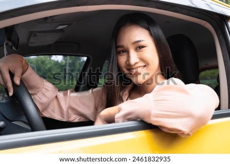 Happy smiling and relaxed woman driver drives with positive emotion, concept image for low reduced gasoline price, good traffic condition, new car, passing driver license, taxi app, Right-side driving Royalty-Free Stock Photo #2461832935