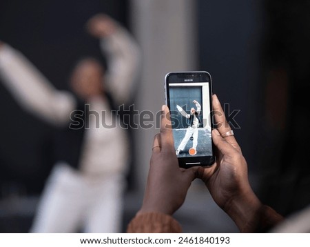 Close-up of woman photographing friend dancing in city