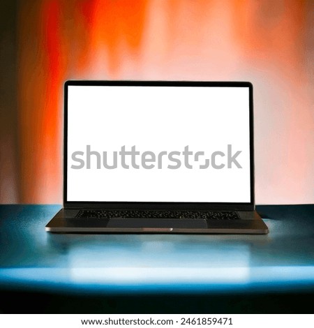A modern laptop with a blank screen is set against a vibrant, colorful background transitioning from red to orange hues. The sleek design of the laptop is highlighted by the illuminated backdrop