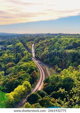 Embark on a journey through nature's wonders with our captivating image of a winding road snaking through lush forest terrain. Ideal for travel brochures, adventure blogs, and inspirational content.