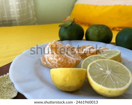 Shelled tangerine with lemon cut on the white porcelain plate