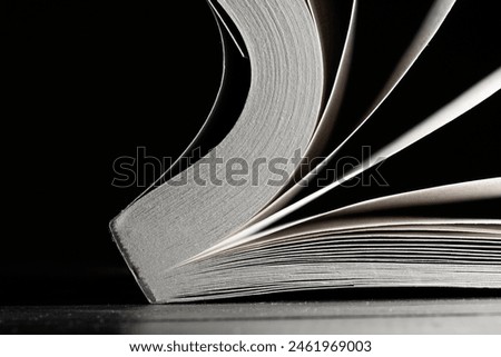 Closeup photo of a book flipping its pages on a black background