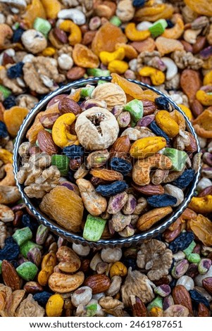 Colorful Mixed Nuts and Dried Fruits in Elegant Bowl, A vibrant, high-resolution image of mixed nuts and dried fruits in a decorative bowl, ideal for healthy snack concepts and nutritional themes.