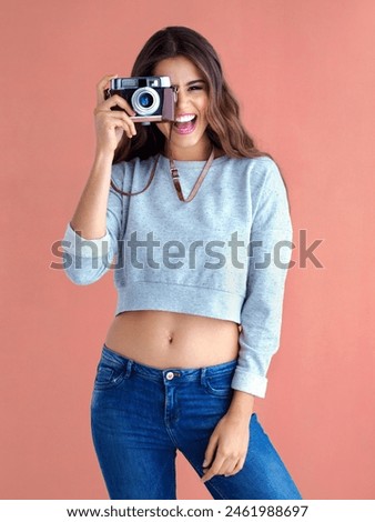 Happy, woman and camera with funny, retro lens and photography in studio with smile. Gen z, vintage and excited with photo and creative college student with photographer and laugh of cool girl