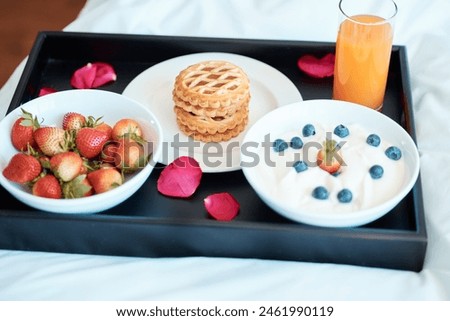 Breakfast, food or plate in bedroom for nutrition, diet and comfort eating on weekend morning. Romance, juice and strawberries together with pancakes in home for health, organic or vegan meal Royalty-Free Stock Photo #2461990119