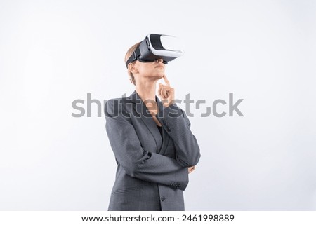 Businesswoman thinking about marketing plan while wearing VR glasses at white background. Manager checking at financial graph while using visual reality goggles. Innovation technology. Contraption.
