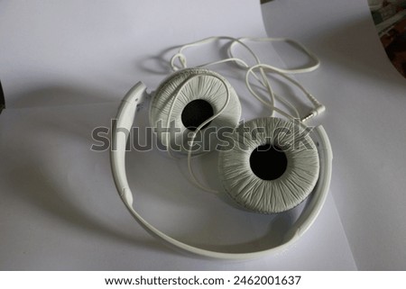 white headphones on a pile of papers