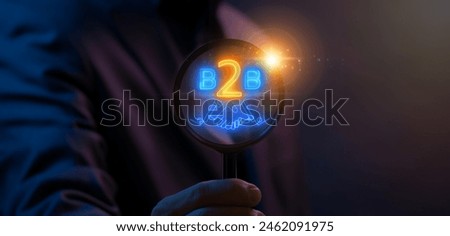 B2B marketing concept. business to business, e-commerce, Professional business and commerce collaboration. Businessman using magnifying glass focus on glowing neon line of hand shaking with B2B icon.