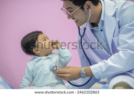 Mail pediatrician doctor in white cost gown hold stethoscope exam child infant patient. pediatrician sitting seduce misbehave baby infant for stethoscope checkup in hospital children medical care Royalty-Free Stock Photo #2462102865
