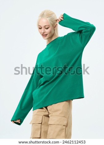 Beautiful girl model in casual clothes. Studio shot on a white background. The blonde smiles.