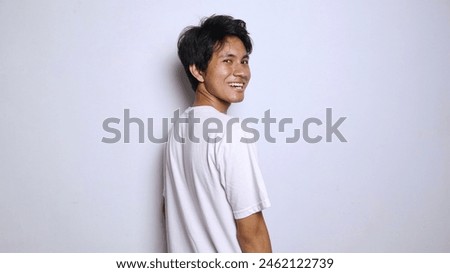 Handsome young Asian man in white shirt with crossed arms on isolated white background