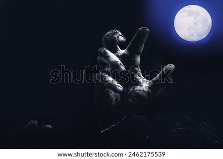 Zombie hand reaching for the full moon. Halloween concept