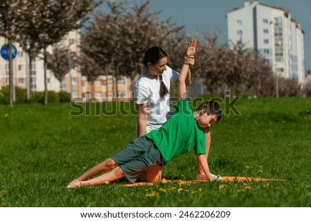 mother does yoga with her son, child does yoga, fitness with kid, children's sports, child does stretching, sports activities, workout, coach trains children