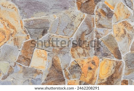 It's photo of mosaic stones in the wall. It is close up view of multicolored stone wall. This is colorful texture for designer. 