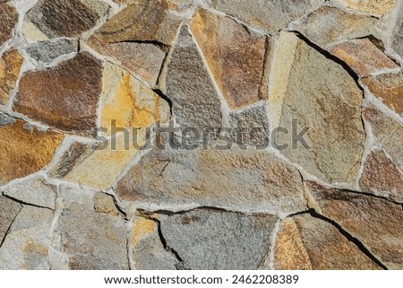 It is a close up view of multicolored stone wall.  It's photo of mosaic stones in wall. This is colorful texture for designer. 