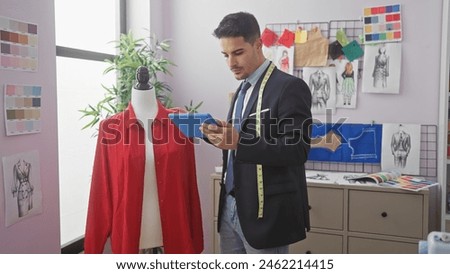 Handsome hispanic man using tablet in fashion design studio with mannequin