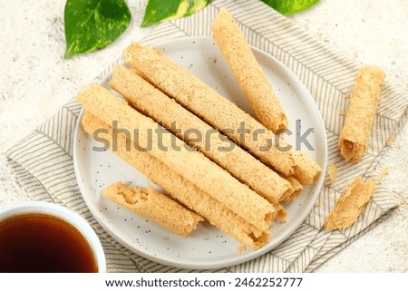Egg Roll Biscuit or Kue Semprong or sapit, Simping, kue Belanda, or kapit or Love letters in English. It is an Indonesian traditional wafer snack Royalty-Free Stock Photo #2462252777