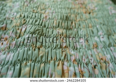 Close view of light mint green rayon fabric with shirring