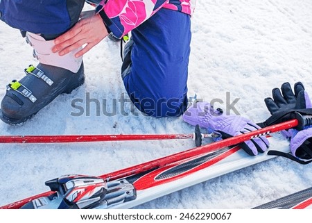 skiers re-strap their boots for a moderately difficult ski slope. Leisure