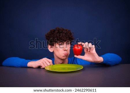 A young funny attractive guy dreams of fast food on a fruit and vegetable diet.
