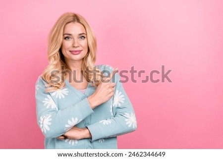 Photo of satisfied woman with wavy hairdo dressed print cardigan directing at discount empty space isolated on pink color background