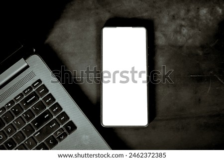 Laptop With blank screen smart phone on dark background