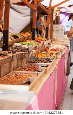 A bustling medieval market stall filled with a colourful assortment of dried fruits and nuts, inviting customers into a world of flavours