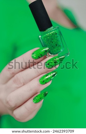 Female hand with long nails and bright green manicure 