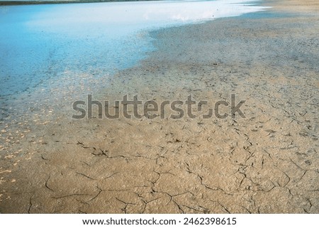 Hydrology. Viscous mud with admixture of clay, sticky clay soil, tough silt, maul. Shallowing and drying process of water basin in hot summer (summer runoff low), drying up river (stage of liquid mud) Royalty-Free Stock Photo #2462398615