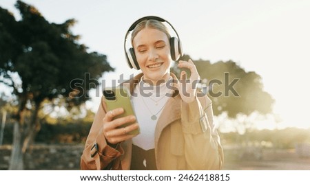 Businesswoman, headphones and cellphone or park walking for work commute, streaming or podcast. Female person, dance and happiness in urban city for morning travel with music, entertainment or audio Royalty-Free Stock Photo #2462418815