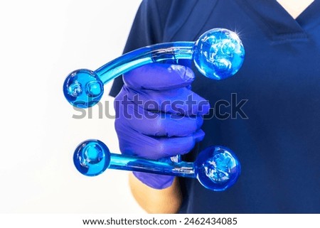 Doctor Holds Blue Acrylic Back, Leg, Neck Massage Tool with Gloved Hand. Deep Tissue Massage, Thumb Massager with Knobs for Gentle Point, Muscles Relaxation. Horizontal. High quality photo