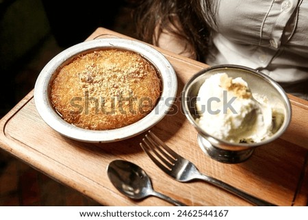 A delectable bowl of ice cream sits beside a scrumptious plate of cake, creating a mouthwatering dessert duo. Royalty-Free Stock Photo #2462544167
