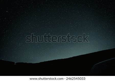A quiet night view with a starry sky and mountain silhouettes