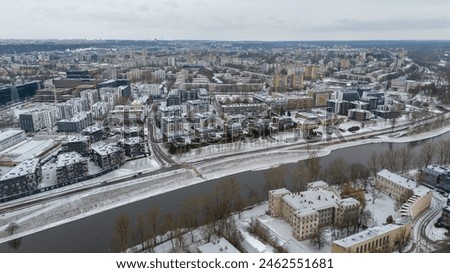 Drone photography of winter cityscape and river flowing through it during winter sunny day