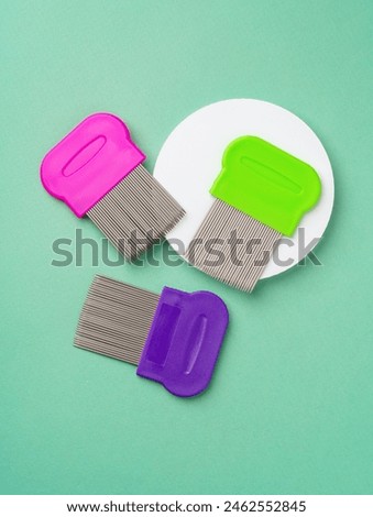 Three combs for lice removing on green background