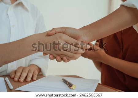 A group of professional businesswomen engaged in a collaborative meeting in a modern office setting. Concentrated and smiling, they discuss ideas and plans for successful teamwork shaking hands