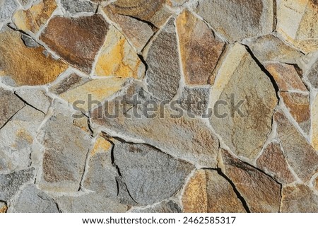 It is close up view of multicolored stone wall.  It's photo of mosaic stones in wall. This is colorful texture for designer. 