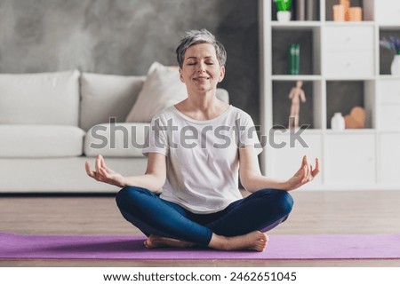 Full size photo of nice retired woman sit mat meditate sportswear sport healthy lifestyle workout modern apartment home living room
