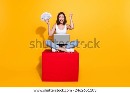 Full length photo of lucky impressed lady dressed white top winning money modern gadget isolated yellow color background