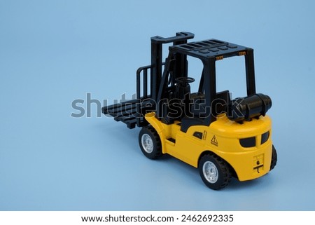  Yellow forklift truck on blue background, space for text.