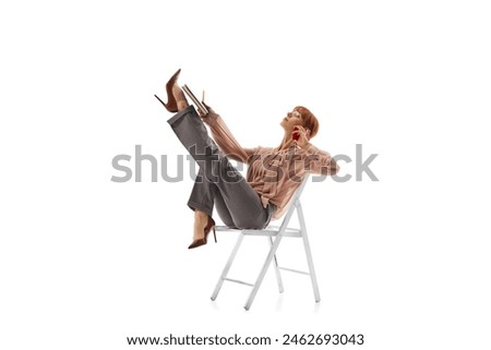 Female employee in forma wear sitting on chair with documents and talking on mobile phone isolated on white background. Concentration and comfort at work. Concept of business, office lifestyle