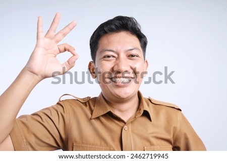 Cheerful Young Civil Government Worker in Uniform Showing Okay Sign Isolated on White Background