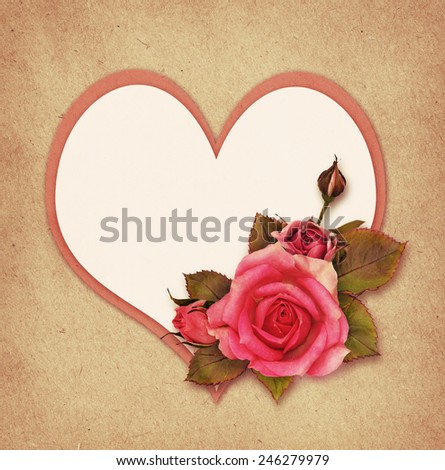Pink rose flowers and a heart on craft paper background for Valentine's Day