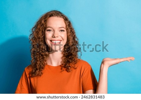 Photo portrait of happy red hair girl demonstrate her handmade surprise holding arm product empty space isolated on blue color background