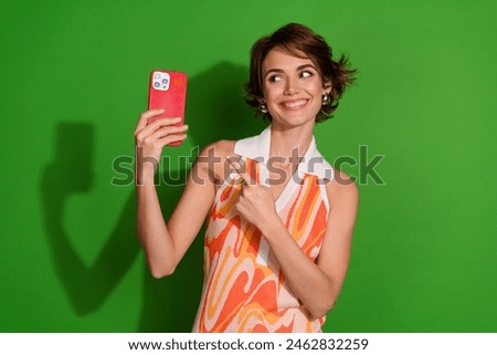 Photo of attractive young woman hold look point device dressed stylish colorful clothes isolated on green color background