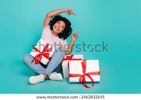 Photo portrait of young positive girl pointing fingers empty space birthday holiday buying pile new presents isolated on cyan color background
