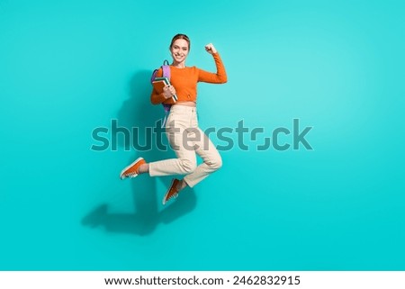Full size photo of overjoyed girl dressed orange shirt backpack on shoulder book flying pass exam isolated on teal color background